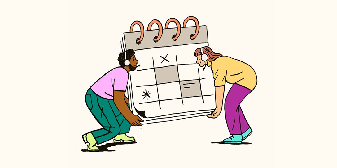 Two people with headsets on are lifting an abnormally large calendar.