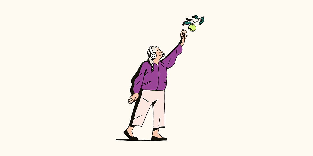 Eine Frau, die ein Headset und eine lilafarbene Jacke trägt, greift nach oben, um einen Apfel von einem Ast zu pflücken.