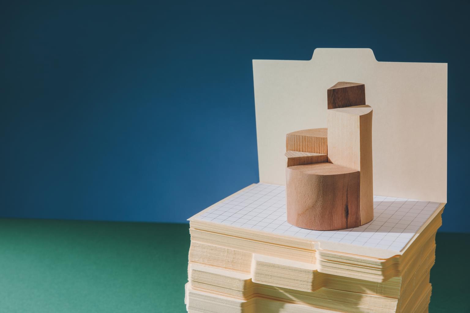 Holzbauklötze bilden auf einem Turm aus Registerkarten eine Art Wendeltreppe.