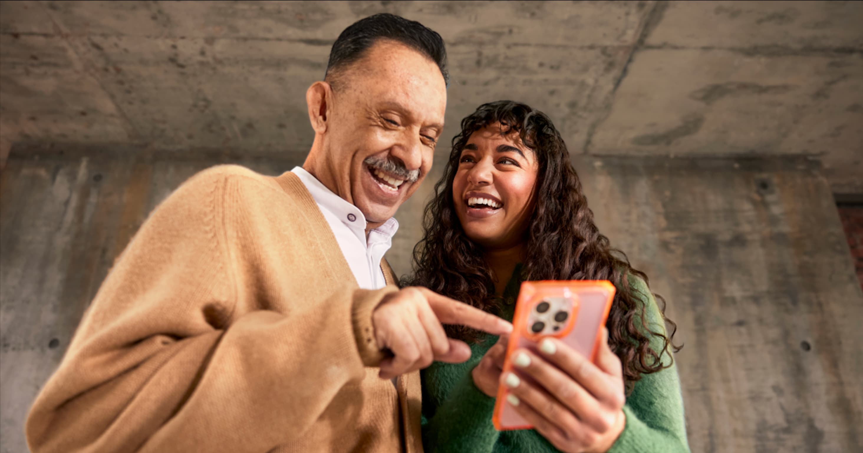 Duas pessoas olham para o celular recebendo atendimento por Whatsapp